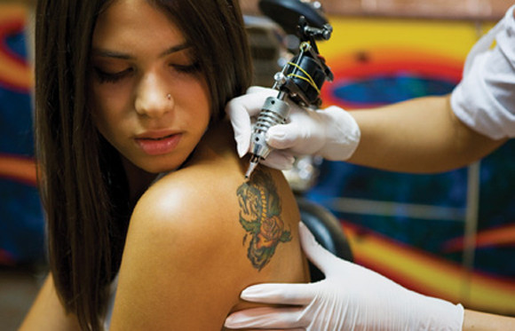 Adolescente haciéndose un tatuaje