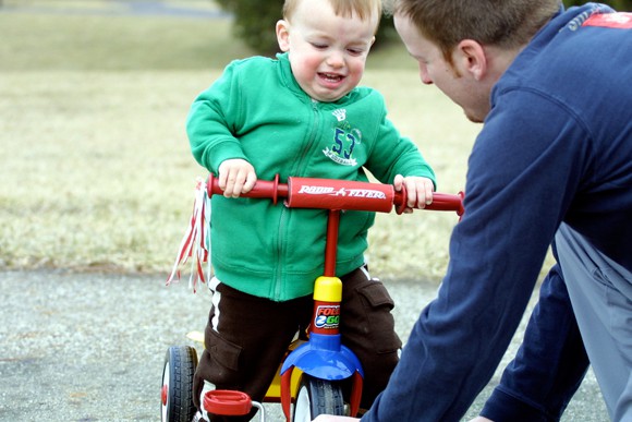 Nen aprenent a pedalejar en tricicle amb el seu pare - Stacy Brunner - Flickr - CC BY-NC-SA 2.0