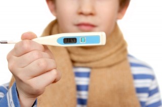 Niño resfriado mostrando un termómetro - FAROS